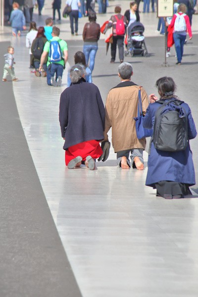 Pilgrims walking the long path of the courtyard on their knees in worship, or looking for a plenary indulgence